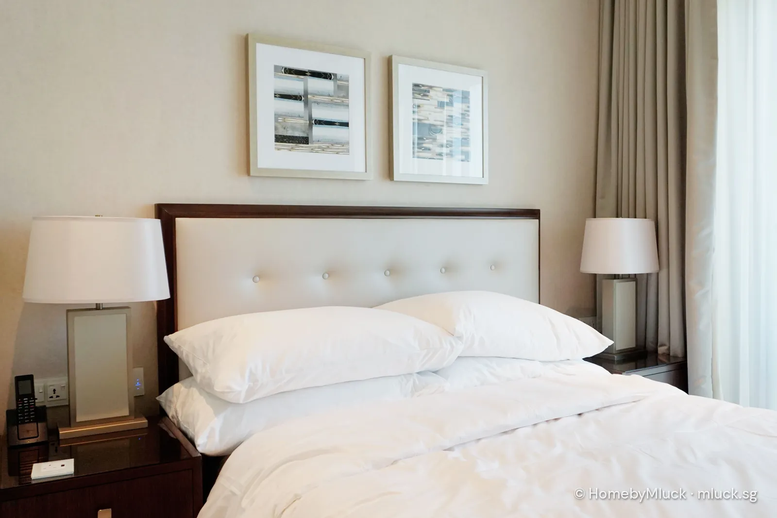 Hotel bed with white pillows, bedside lamps and phone — licensed Pexels photo