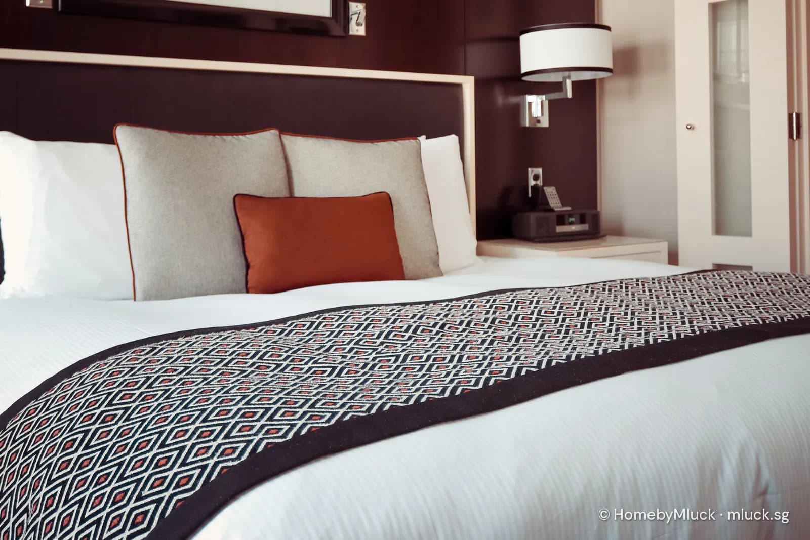Neatly made hotel bed with pressed white linen and bed runner — licensed Pexels photo